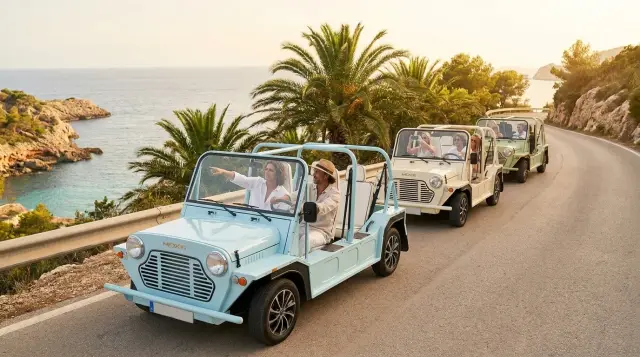 Light blue electric Kate Moke guided tour on Ibiza beach boardwalk at golden hour — couple with expert guide, Retro Rides